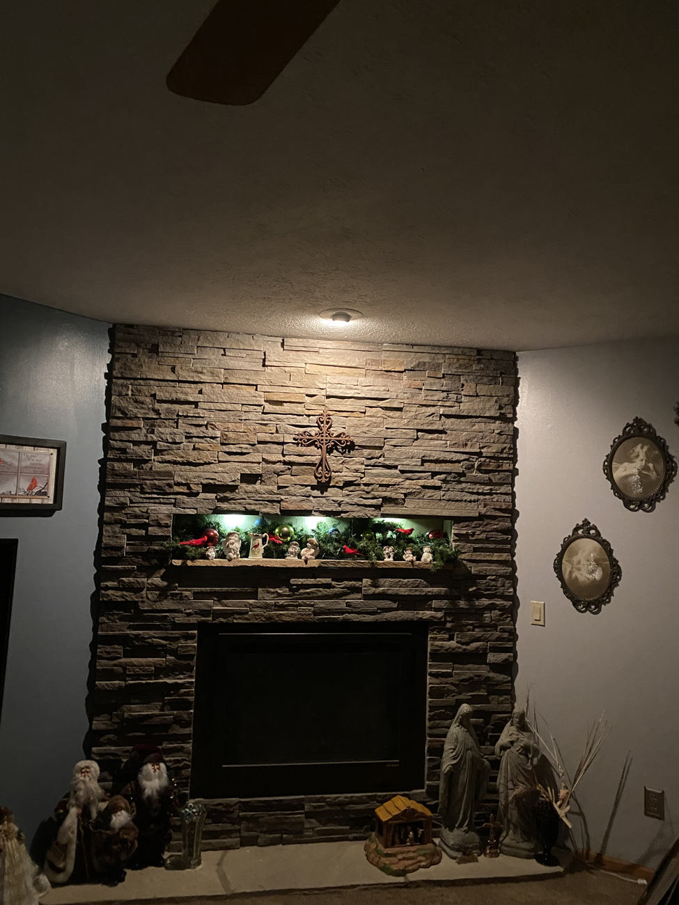 Residential stone fireplace wall with a recessed display above the mantel